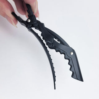 Image of Black Darby Clip being pinched open showing the rigid texture on the side..
