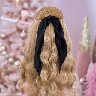 image of long golden hair styled in with a Beachwaver hair-tool pulled away from the face in a Black Silky hairscarf.