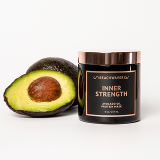 Image of Inner Strength Avocado Oil Protein Mask with a cut open avocado next to it.