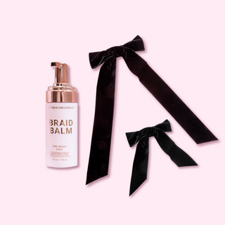 Pink and rose gold foam pump Braid Balm hair product next to 2 black velvet bows one large and one small