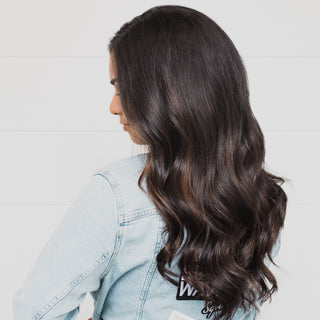 Model with dark brown hair that is styled into loose waves by the Beachwaver S1.25.