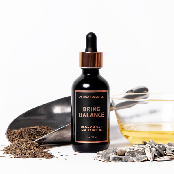 Image of Beachwavers Bring Balance Organic Argan + Marula Hair Oil surrounded by its ingredients.