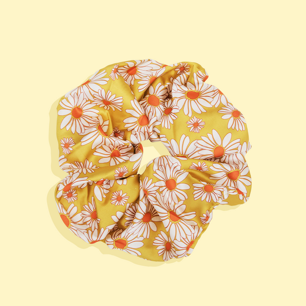 image of Oversize yellow daisy scrunchie on yellow background