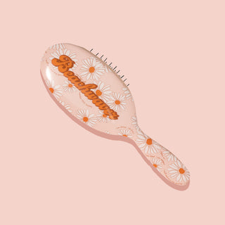 Image of  On-Set Styling Brush that is pink with white and orange daisies on it.