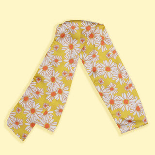 Image of yellow hair scarf with daisies on it on a yellow background