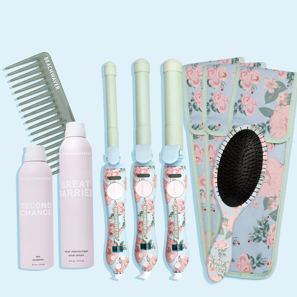 Image of floral pro collection which includes a green wide tooth comb, a pink aerosol bottle of second chance dry shampoo, another pink aerosol bottle of great barrier heat protectant hairspray, all three sizes in the Floral S Beachwaver series of the blue and green with pink flowers and greenery, three storage pouches to hold those Beachwaver's and those come in blue with pink flowers and greenery, and lastly a blue brush with pink flowers and greenery