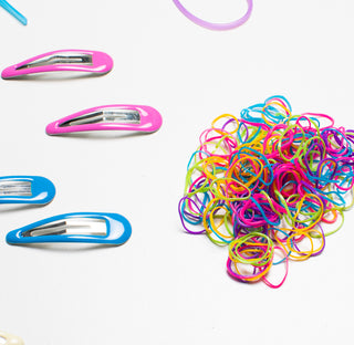 Image of pink and blue hair clips and a pile of assorted neon colored hair rubberbands