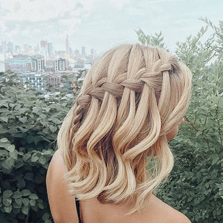 Blonde model with shoulder length hair styled in a waterfall braid that goes across her head.