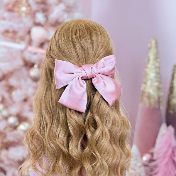 image of long golden hair styled in with a Beachwaver hair-tool pulled away from the face in a Pink Silky Oversized Hair Bow.
