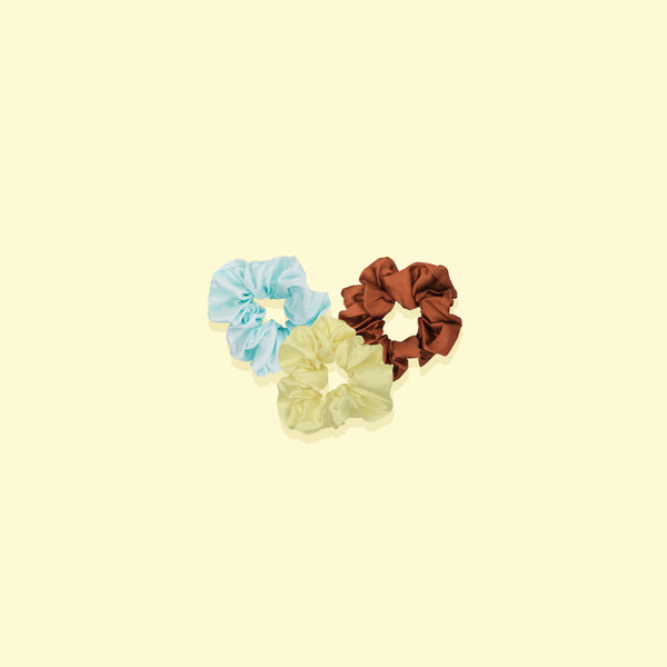 Image of three small scrunchies in color is cream, blue and burnt orange