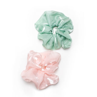 Two oversized scrunchies in a shimmery pink and a shimmery pastel green