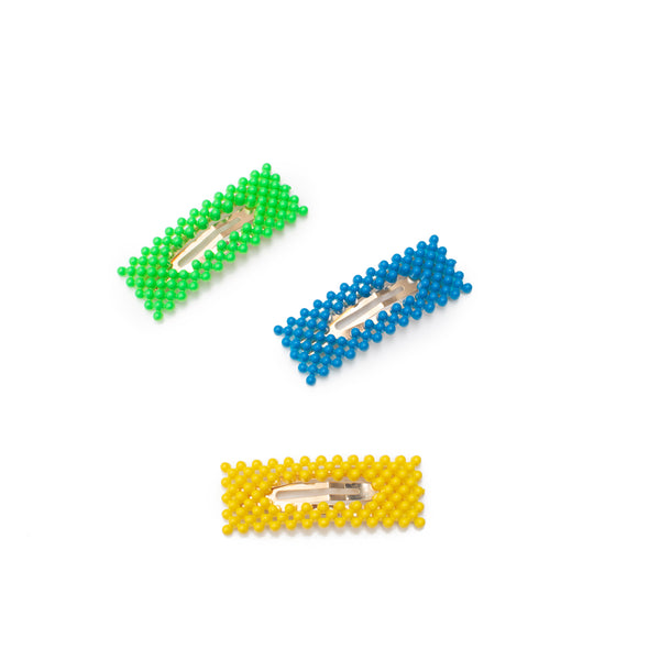 Image of three bumpy hair clips in the colors neon green, neon blue, and neon yellow