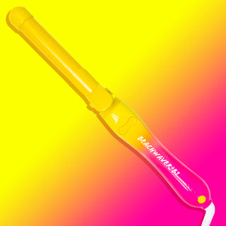 Yellow and pink ombre neon Beachwaver B1 on a matching ombre background.
