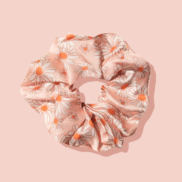 Image of oversized pink daisy scrunchie on a pink background