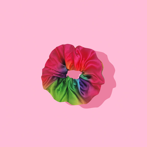 Image of tie-dye rainbow scrunchie on pink background