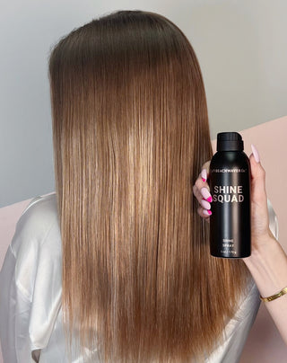 Image of back of head of sleek hair that had shine squad shine spray applied to it  