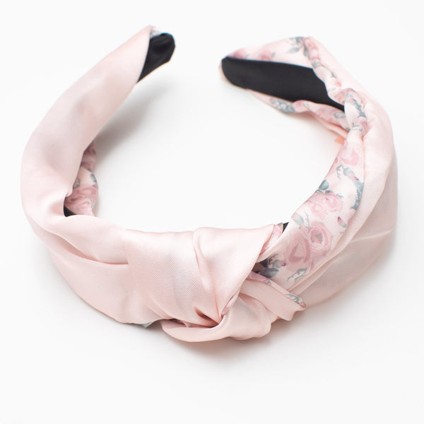 Image of silky floral pastel pink headband with a knot from the top angle.