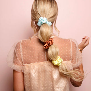 Image of blonde model with three scrunchies in her hair creating a bubble braid