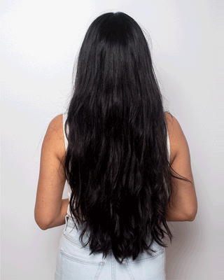 Gif of model with long brunette hair with a diagonal bar sliding across the screen showing the before of the hair being tangled and messy to smooth and sleek.